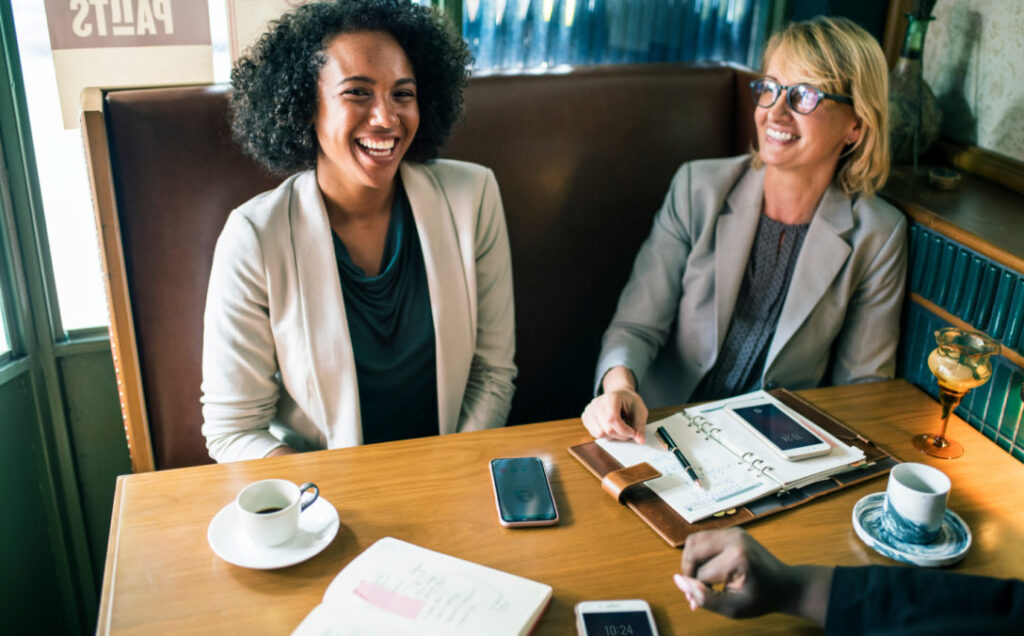 Two women interview a new hire, using human-centered design tools to retain top talent in the insurance industry.