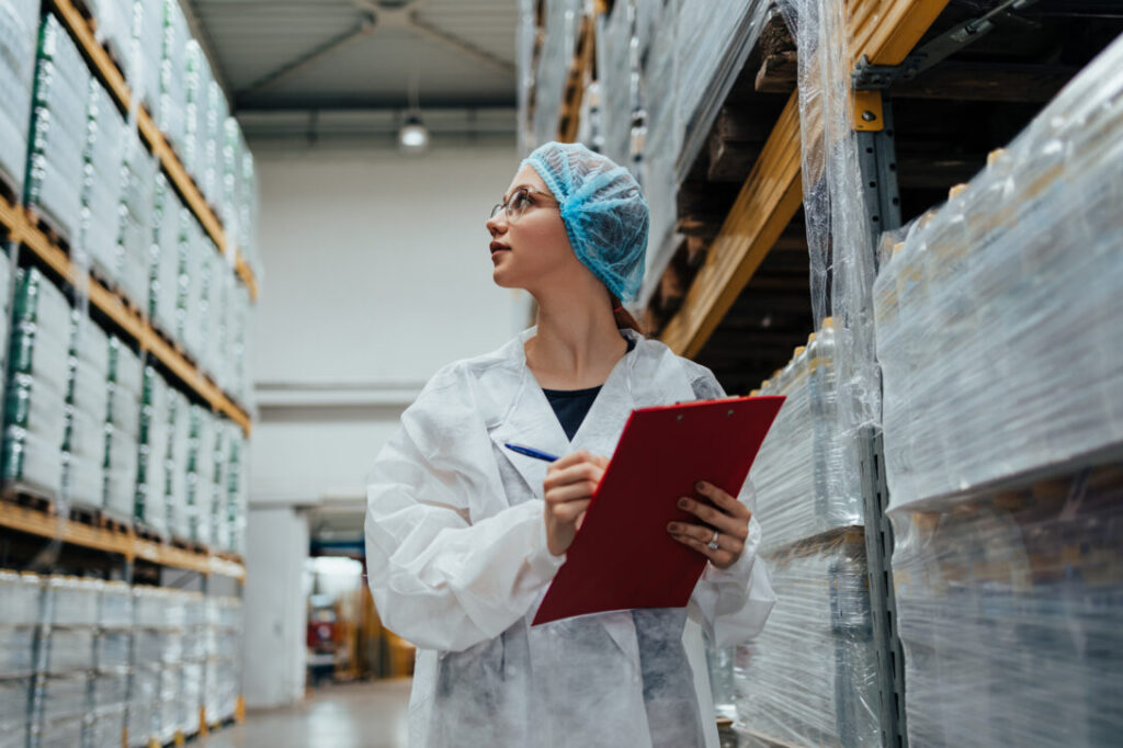 Inspector in protective gear examining products, representing the impact of innovation training in the healthcare industry.