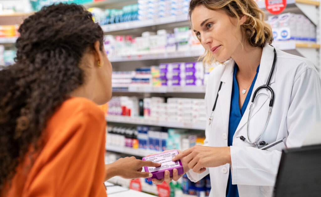 A pharmacist consulting with a customer, representing the impact of innovation training in the healthcare industry.