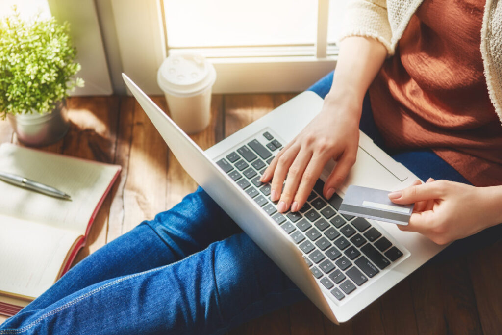 Person shopping online with a credit card representing the impact of design thinking training in the retail industry.