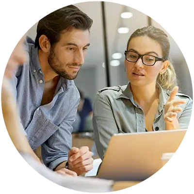 Man and woman working on a change management challenge on a laptop.