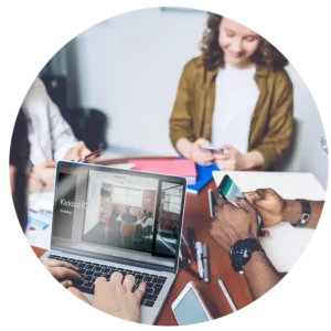 A group of people participating in an experiential workshop using their laptops and mobile devices.